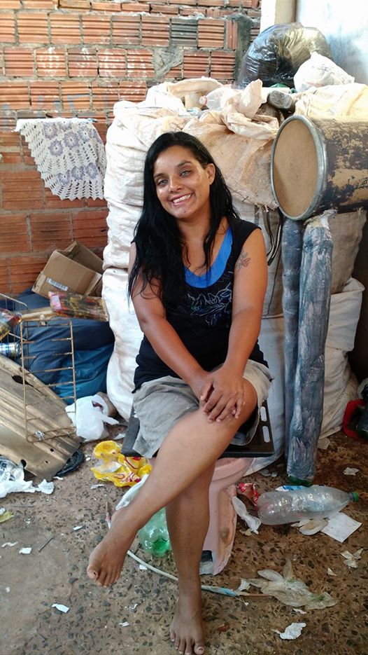 A catadora Cacilda Souza sentada em um banco improvisado para a gravação de seu vídeo: um vaso sanitário abandonado em um terreno baldio, cheio de larvas de mosquito, por ela reaproveitado